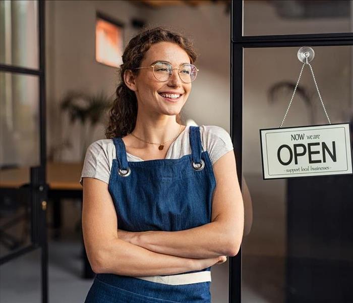 Small business owner standing at cafe entrance
